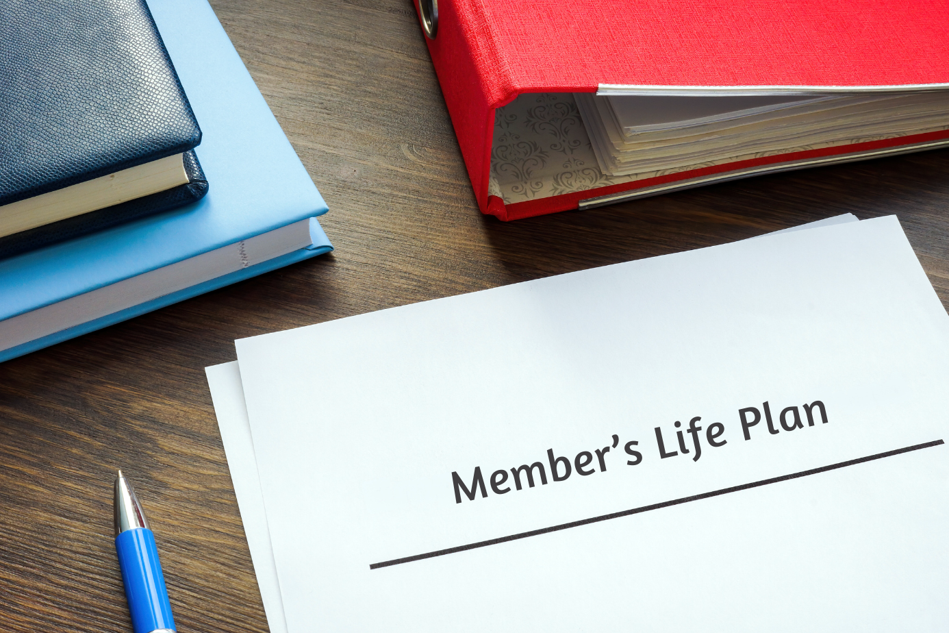 stacks of books and a pen appear need a document that reads &quot;Member&#039;s Life Plan&quot;