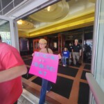An ADA marcher exits the Kallet Civic Center in Oneida. An ADA marcher exits a public building with a sign that reads "Americans with Disabilities Act"