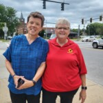 Karen Hoffman, LIFEPlan Director of Provider Relations, stands with Bonnie VanDusen of the Madison Cortland ARC Sunshine Choir Two women stand on the sidewalk together.