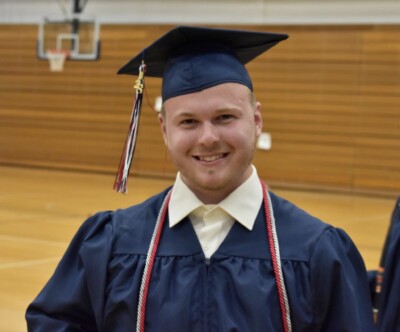 Smiling LIFEPlan Member, Aiden Forshey in his cap and gown at graduation.